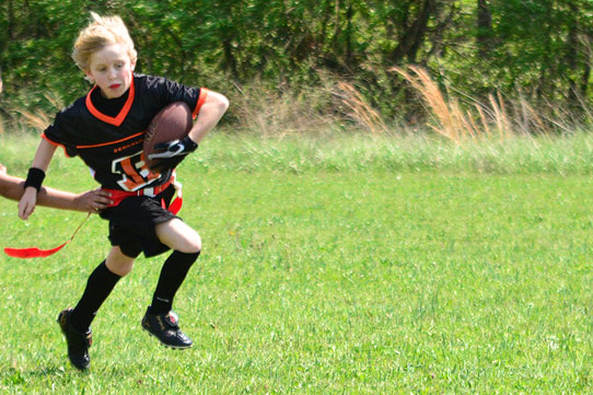 boy running with football