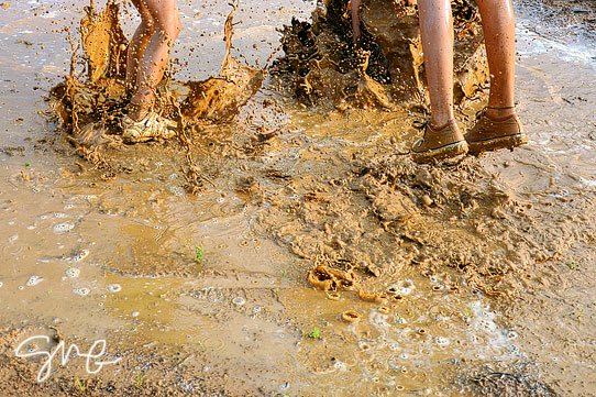 Kids jumping in mud puddle